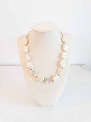Necklace with large beads on a mannequin bust against a white background